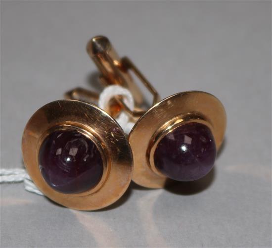 A pair of yellow metal and cabochon star ruby set cufflinks.